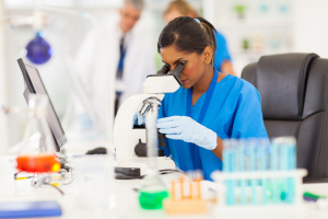 young medical researcher looking through microscope